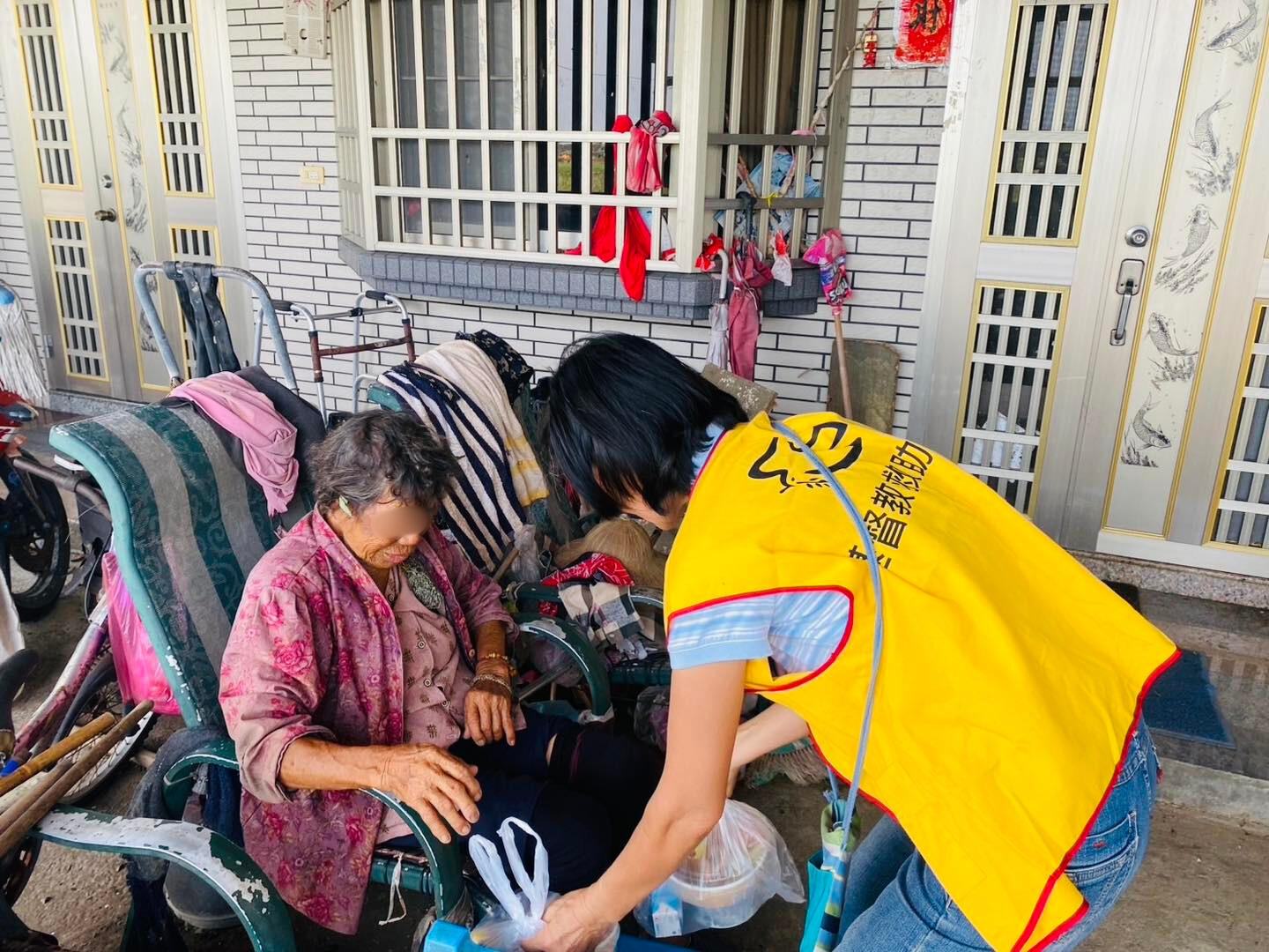 7月12日 行動不便的阿嬤 接過便當 笑著對台南神召會志工說:「我肚子好餓，謝謝你們！」(救助協會提供)